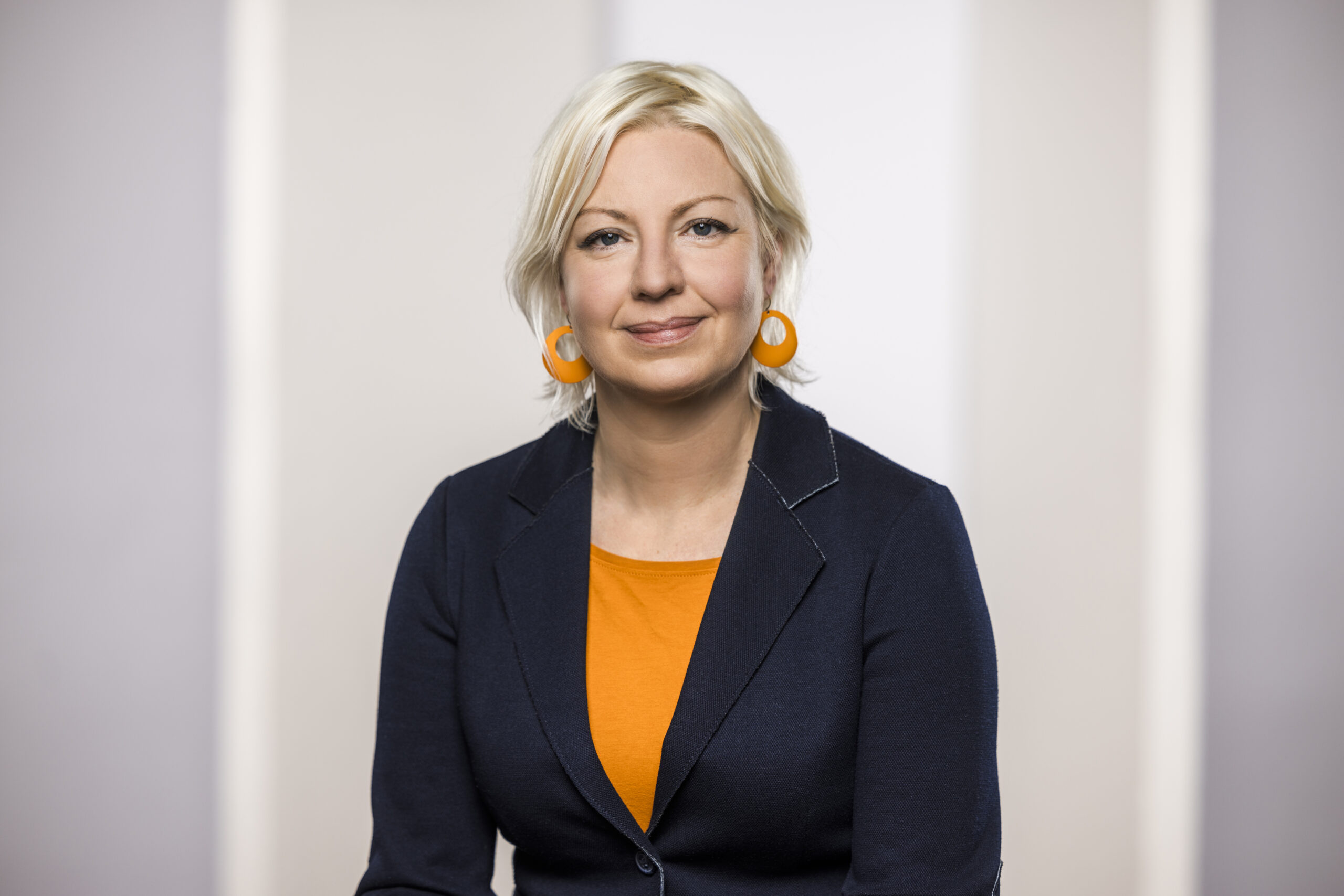 Die düsseldorfer Bürgermeisterin Clara Gerlach sitzt vor grauem Hintergrund.
